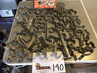 Large collection of metal cookie cutters of various themes spread out on a table showing diverse shapes and sizes.