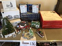 Full lot overview showing village houses, skating pond, ox sled, boxed light sets and window decorations.