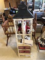 Front view of the rustic holiday lantern cabinet with Santa inside
