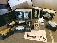 Full view of 12 Snowbabies collectible items including boxed sets and single figurines spread on a table with lot number card visible.