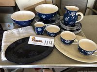 Photo showing the full set of snowflake dinnerware and serving pieces arranged on a table along with the beaded table runner and placard with lot number