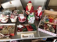 Overall lot showing bubble light boxes, metal tin, plastic figurines, handmade ornaments