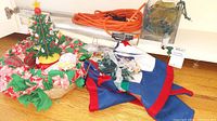 Photo showing the full lot with the wooden Christmas tree, fabric tree skirt, ornaments, and string lights laid on a wooden floor.