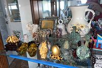 Display case with elephant figurines, St. George floral pitcher, gold-colored small ornaments