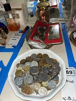 Plate of mixed foreign coins showing various sizes, metals, and denominations.