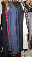 Eight men's jackets, coats and shirts on hangers showing variety of colors and styles