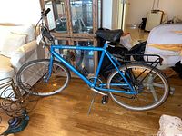 Side view of assembled bike showing frame, wheels, saddle, rear rack and kickstand