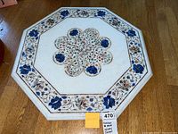 Top-down view of the octagonal Moroccan stone lazy Susan showing central floral inlay and border pattern.