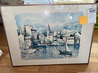 Photo of the full framed watercolor painting showing the coastal town scene and wooden frame with mat border.