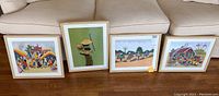 Full set of four framed art prints arranged on the floor, showcasing size and frames
