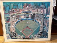 Full view of the framed colorful print illustrating Yankee Stadium packed during a night game with cityscape background.