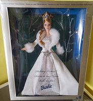Barbie doll in original box wearing silver dress and white faux fur trimmed cape, showing overall front view.