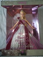 Front view of boxed 2005 Mattel Holiday Barbie Holiday doll designed by Bob Mackie in fuchsia and silver with box branding