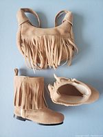 Close-up of tan fringe purse and single fringe boot showing detail, materials and size