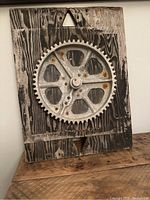 Full frontal image of the wooden factory mold with metal cog wheel mounted at center, showing wear and patina.