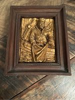 Front view of hand carved wooden 3D fisherman art plaque with frame and detailed carving