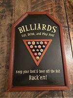 Full front view of the billiard sign mounted vertically, showcasing the text and wooden frame.