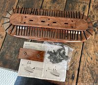 Wooden finished tie rack with multiple black tie holders, mounting hardware and instructions visible.