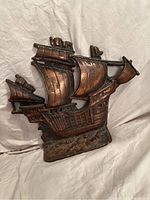 Front view of the vintage cast iron ship-shaped doorstop with detailed sails and hull.