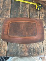 Top-down photo showing full cheese board on rustic wood surface with measuring tape indicating approximate dimensions.