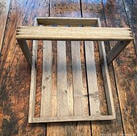 Top view of vintage handmade wooden egg basket showing flat handle and wood slats base.
