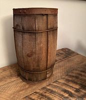 Front angle showing wooden nail bin with metal bands and aged wood surface on a wooden table.