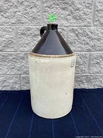 Full view of 5-gallon stoneware crock with light beige body and dark brown glazed top and handle, marked with number 5 on the body.