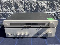 Front view of Harman Kardon TU905 stereo tuner stacked atop PM625 amplifier showing controls and knobs on both units.