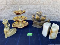 Photo showing all four items: onyx bookends, brass ship lamp, candy dish, and ceramic figure.