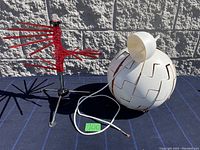 Both items in the lot visible: white spherical hanging lamp with wave patterned cutouts and red Tacapasta pasta drying rack with multiple extendable red arms on chrome tripod base
