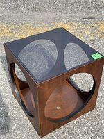 Front angle showing wood cube frame with circular cutouts and glass top