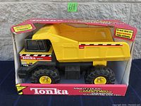 Front view of the Tonka Mighty dump truck in its original box showing size and branding.