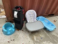 Photo showing the blue infant bathtub, black foldable travel playpen, grey padded Graco high chair with tray, and blue Bumbo infant seat.