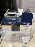 Four electronic deadbolt boxes in plastic bin showcasing seller packaging and branding with clear visibility of Weiser Elements labeling.