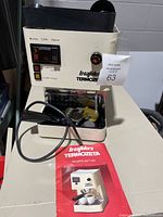 Full front view of the Termozeta la caffettera espresso/cappuccino machine showing front control panel and instruction manual placed at the base