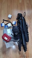 Top view showing collection including tripod, pelican cases, camera, boxed items, and accessories.