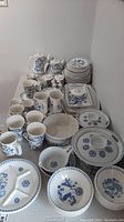 Overall selection of plates, bowls, mugs, cups and pots arranged on table