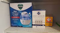 Photo showing Vicks Mini CoolMist humidifier box, PSP Isopropyl Alcohol 99% box, and Arm & Hammer Baking Soda box on a speckled white surface.