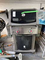 Front view of Weber Spirit grill showing hood, control panel and folded side shelves