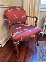 Three-quarter front-right view of bergère chair showing overall shape, wood frame and upholstery pattern.