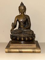 Frontal view of the Buddha statue showing detailed robe patterns and lotus base on book platform