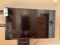 Front view of Samsung 32-inch LED TV powered off, with black bezel and wall mount visible.