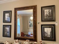 Photo of all four framed black and white photographs arranged on a wall, showing their size and style