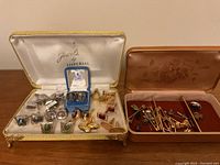 White-velvet Imperial box open showing silver-tone and gold-tone cufflinks on display