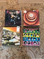 Four vinyl record albums arranged in a 2x2 grid: KISS “Alive!”, Stevie Wonder “Songs in the Key of Life”, Led Zeppelin “Houses of the Holy”, The Rolling Stones “Some Girls”