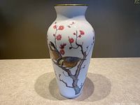 Front view of Franklin porcelain vase with a bird on cherry blossom branch, gold trimmed rim.