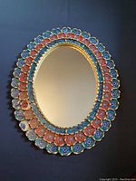 Front view of the oval mirror showing the multi-colored floral hand-painted glass panes and bronze leaf detailing.