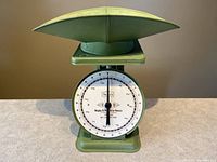Front view of Sears kitchen scale showing circular white dial with weight markings and farmhouse green scale body and platform.