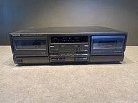 Front view of Technics RSTR170 stereo cassette deck with cassette compartments closed, showing control buttons and digital display.