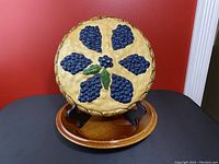 Front view of ceramic pie dish with detailed blueberry and leaf design on lid